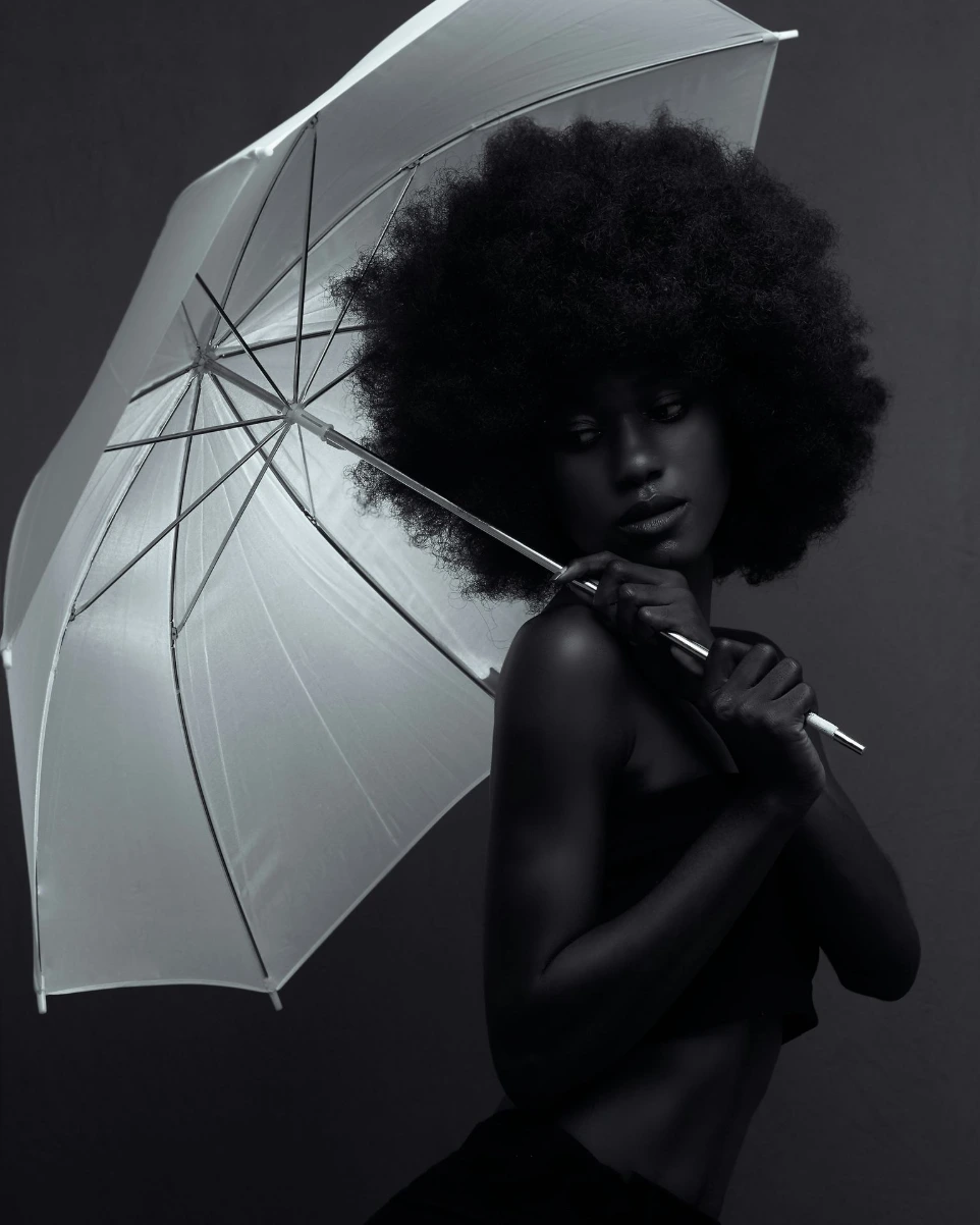 A woman holding an umbrella in a black and white photo